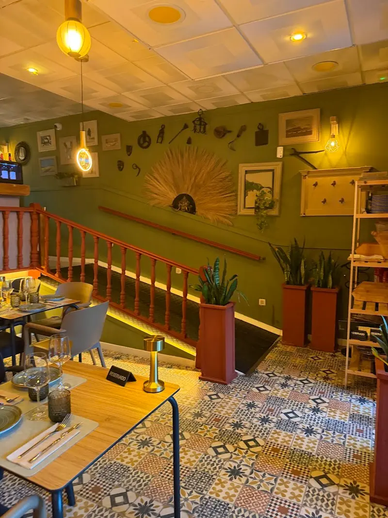 Comedor con suelo hidráulico, paredes verdes, escalera de madera y mesas preparadas