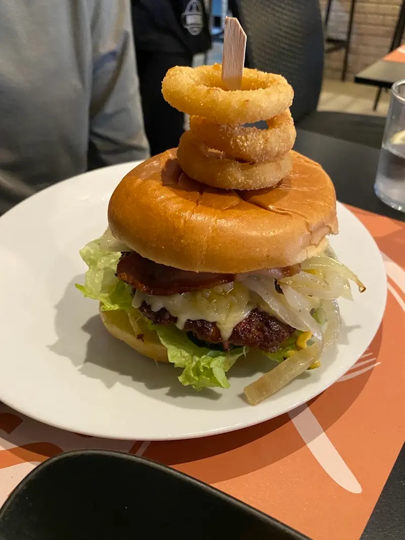 Hamburguesa con queso, bacon, cebolla y lechuga coronada con aros de cebolla