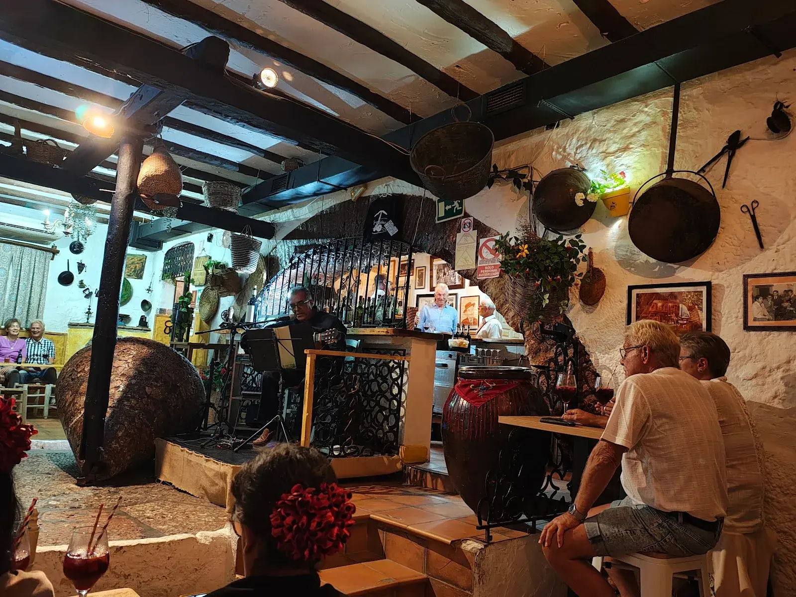Música en directo en El Molino con el público sentado junto a la piedra del molino