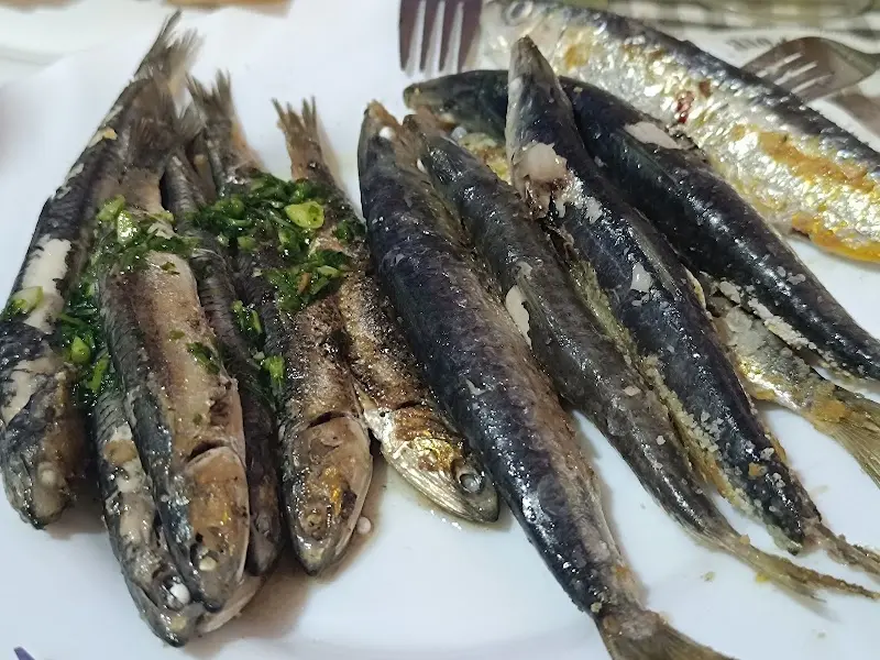 Sardinas a la plancha con ajo y perejil en un plato blanco