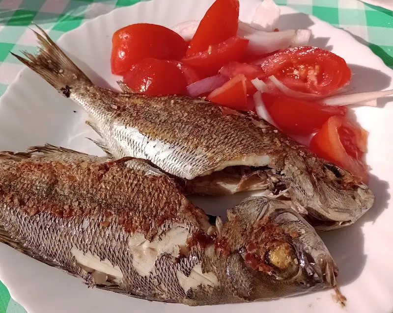 Dos pescados a la plancha con ensalada de tomate y cebolla