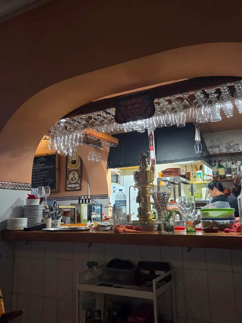 Arco sobre la barra con tirador de cerveza, pizarra y copas colgadas