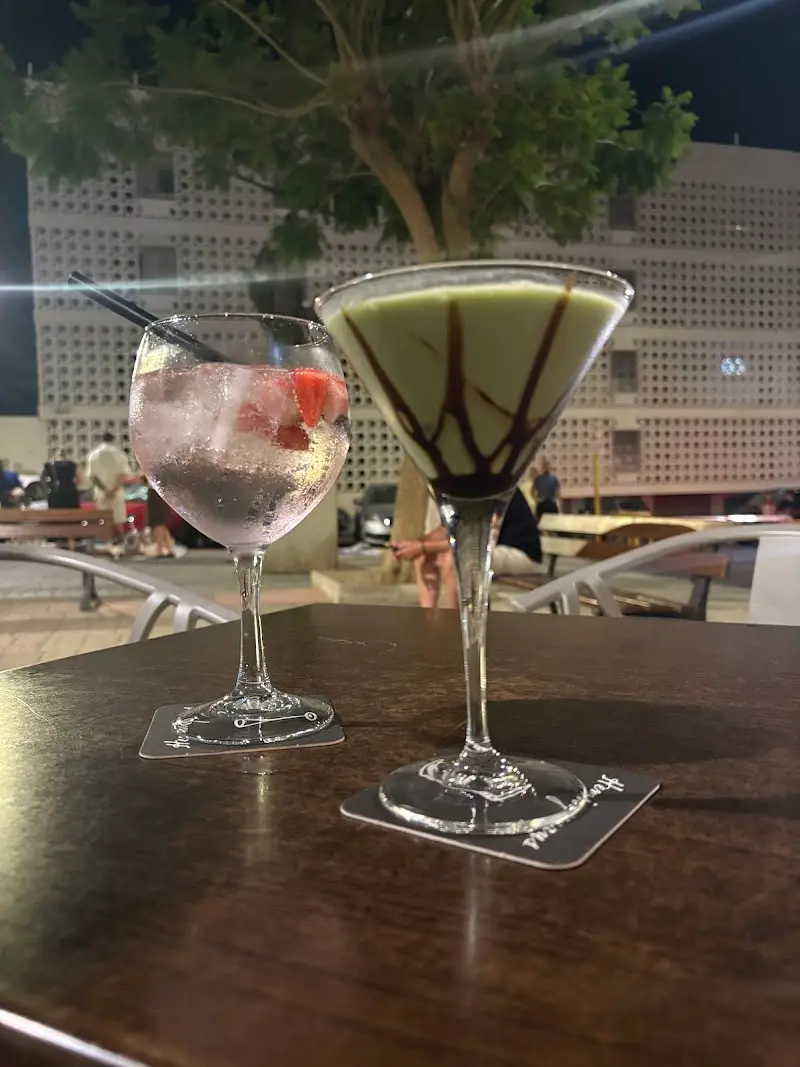 Gin-tonic con fresas y cóctel verde con sirope de chocolate en la terraza de noche