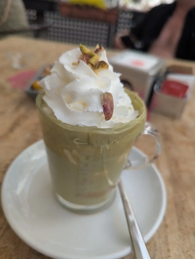 Batido de pistacho con nata montada y pistachos troceados en vaso de cristal