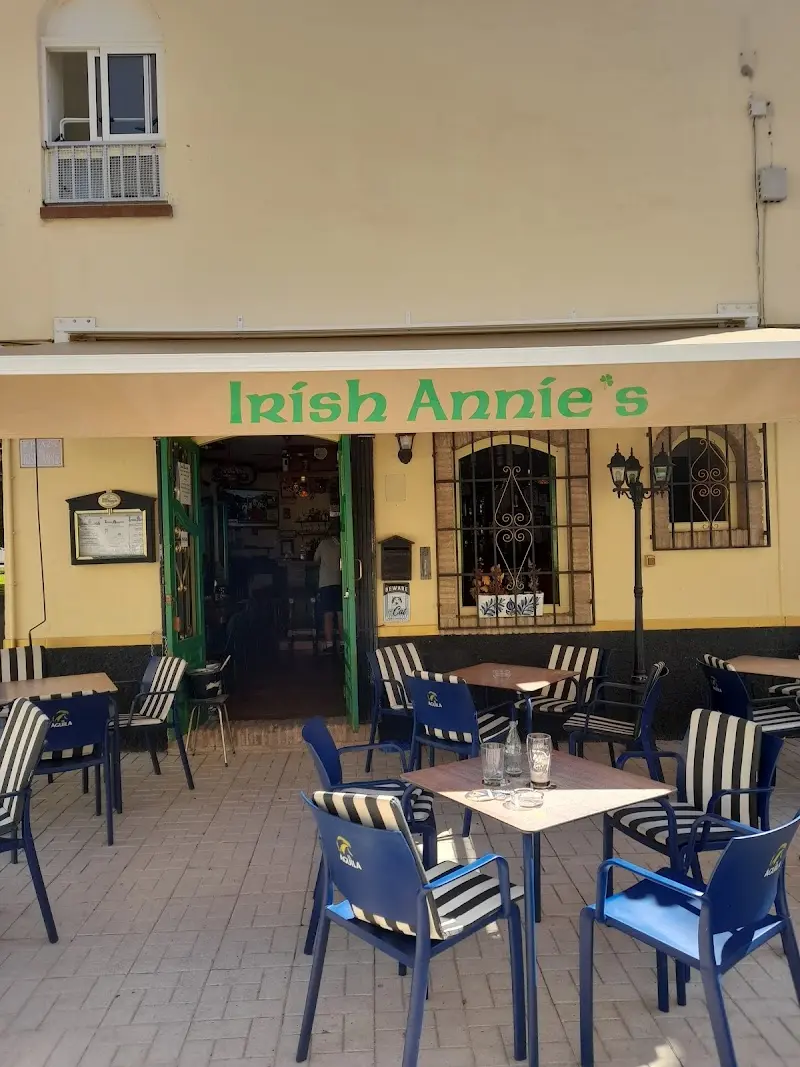 Terraza con sillas azules y a rayas bajo el toldo verde y crema de Irish Annie's