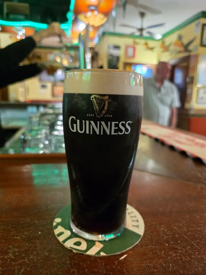 Pinta de Guinness sobre un posavasos en la barra de madera