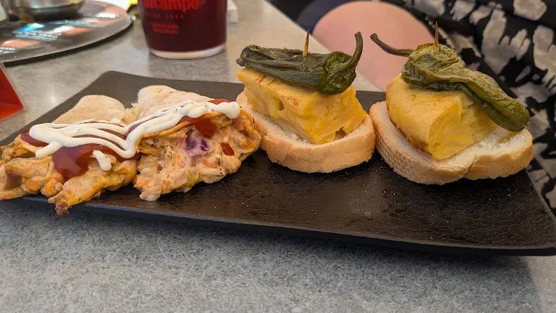 Montaditos de tortilla de patatas con pimiento frito y una tapa con salsa rosa