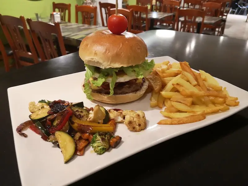 Hamburguesa con lechuga y queso, patatas fritas y verduras salteadas