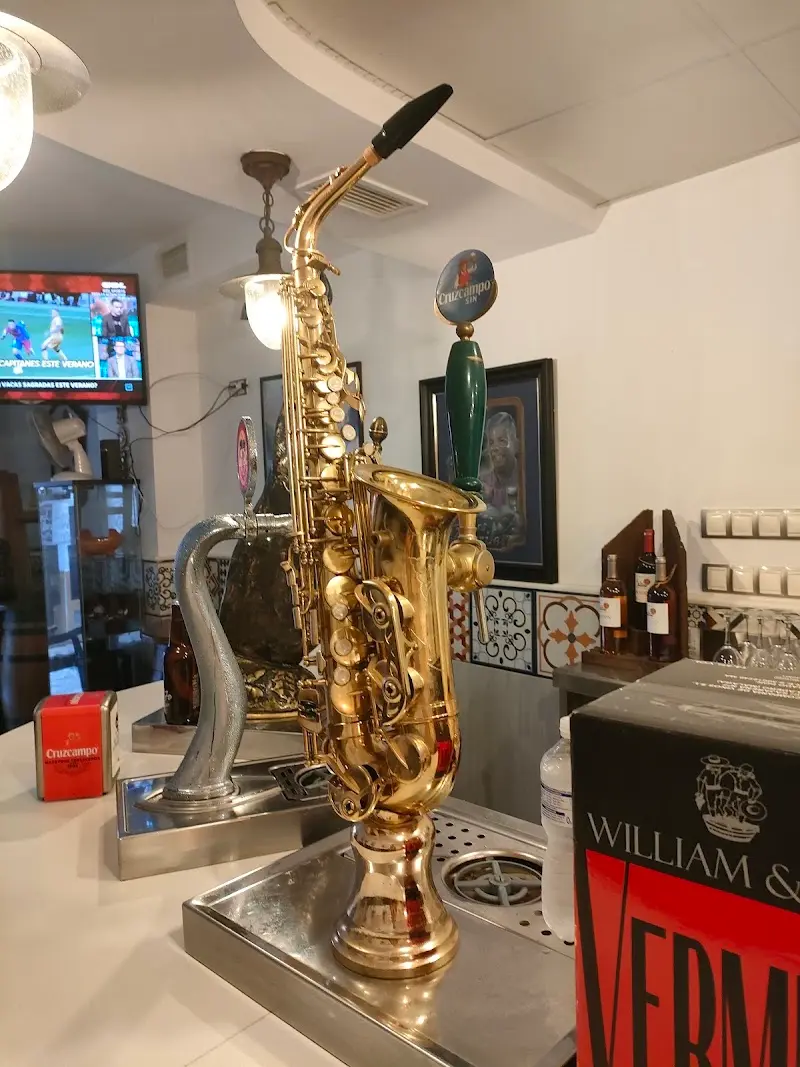 Grifo de cerveza con forma de saxofón dorado sobre la barra
