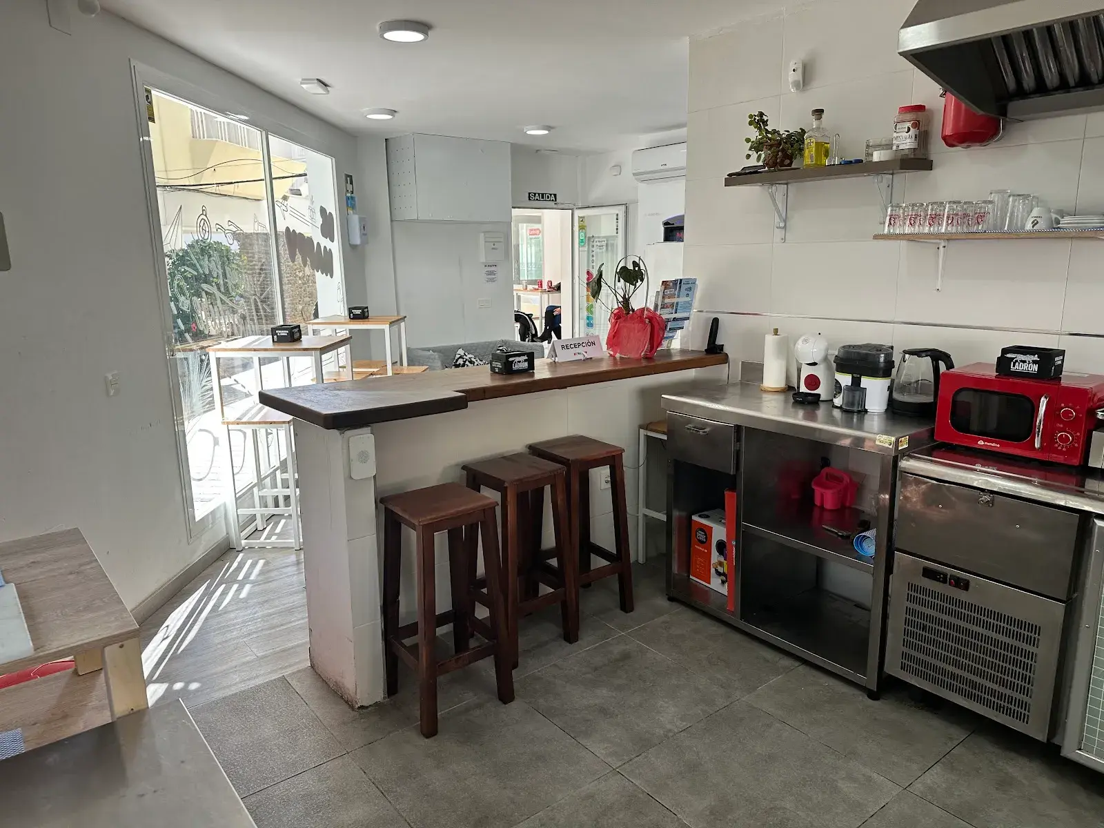 Cocina compartida con barra, taburetes de madera, microondas y hervidor