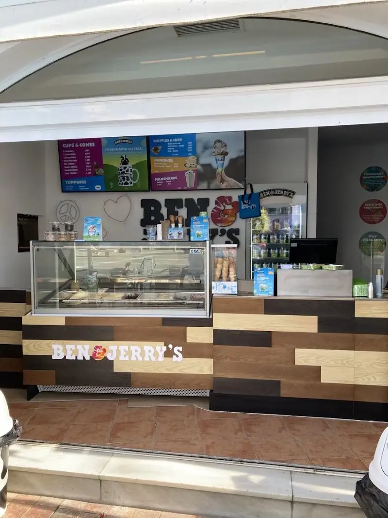Mostrador de madera con la vitrina de helados y pantallas de carta de Ben & Jerry's Nerja