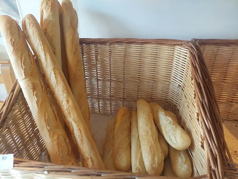 Barras de pan y bocadillos recién horneados en una cesta de mimbre