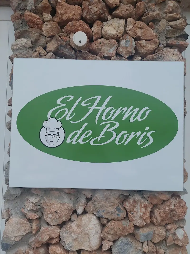 Cartel verde de El Horno de Boris sobre una pared de piedra