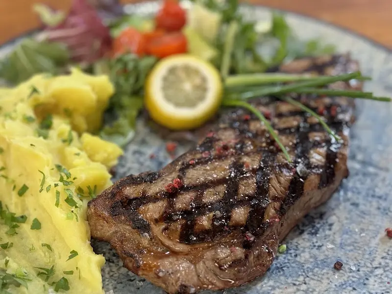 Filete marcado a la parrilla con puré de patata, limón y ensalada