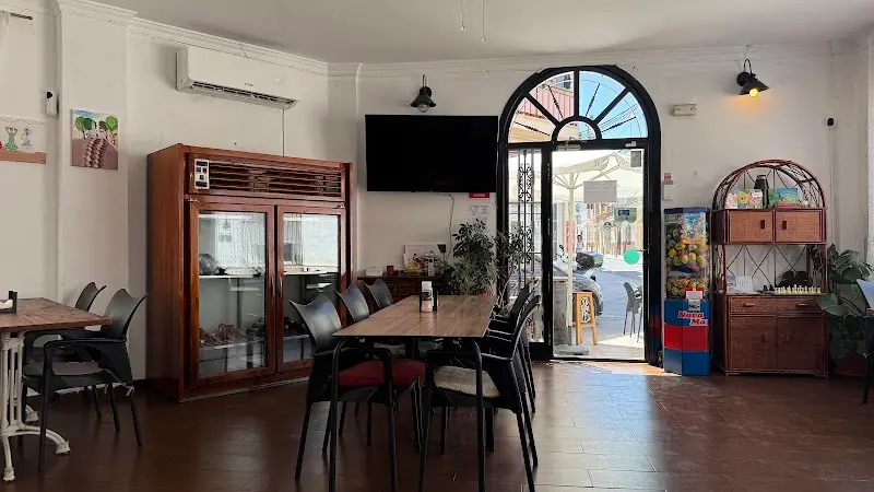 Comedor con mesas de madera, vitrina de carnes y puerta de arco abierta a la calle