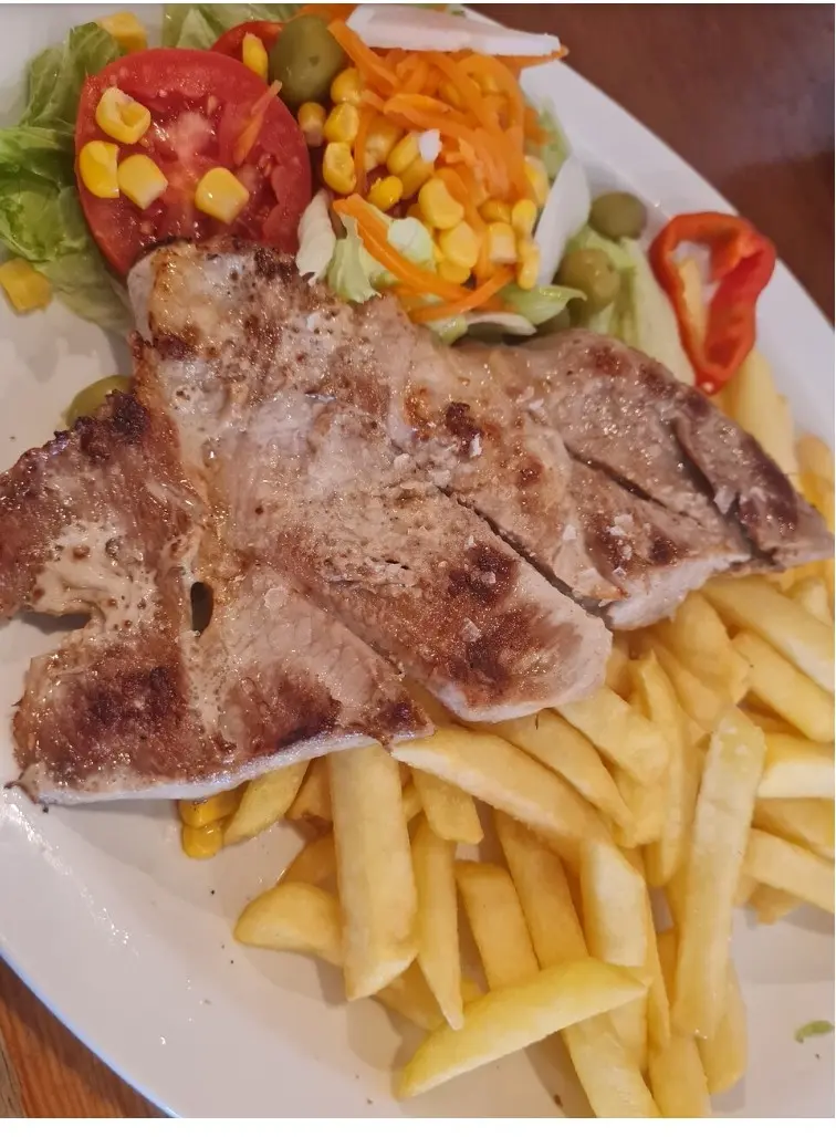 Filete a la plancha con patatas fritas y ensalada con maíz y zanahoria
