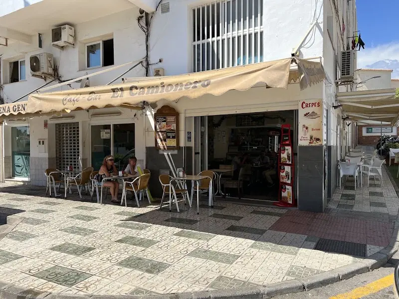 Esquina del Café Bar El Camionero con toldo, terraza y cartel de crepes