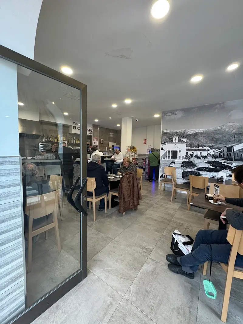 Interior de El Colorao con clientes en las mesas y una gran foto antigua de Nerja en la pared