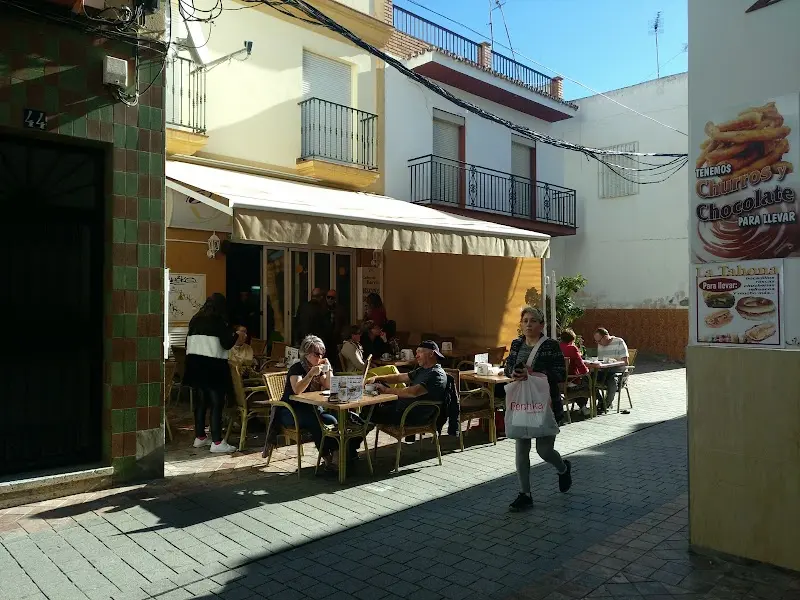 Terraza con clientes bajo el toldo en una calle peatonal del centro de Nerja