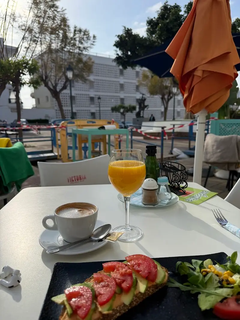 Desayuno en la terraza: café con leche, zumo de naranja y tostada con aguacate y tomate