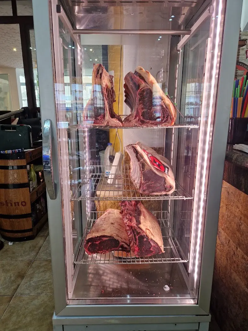 Cámara de maduración con piezas de carne de vacuno en estantes de rejilla