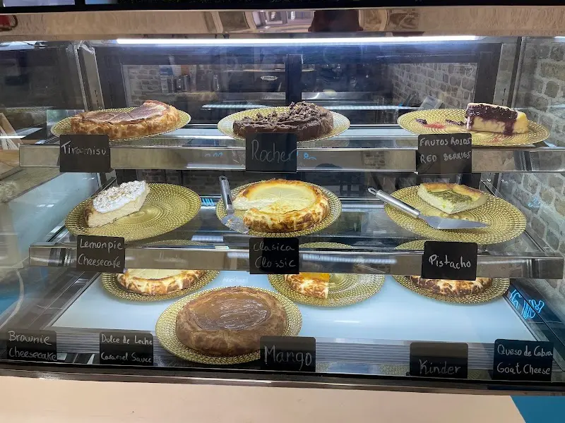 Vitrina con tartas de queso de sabores: tiramisú, Rocher, pistacho, mango, Kinder y más