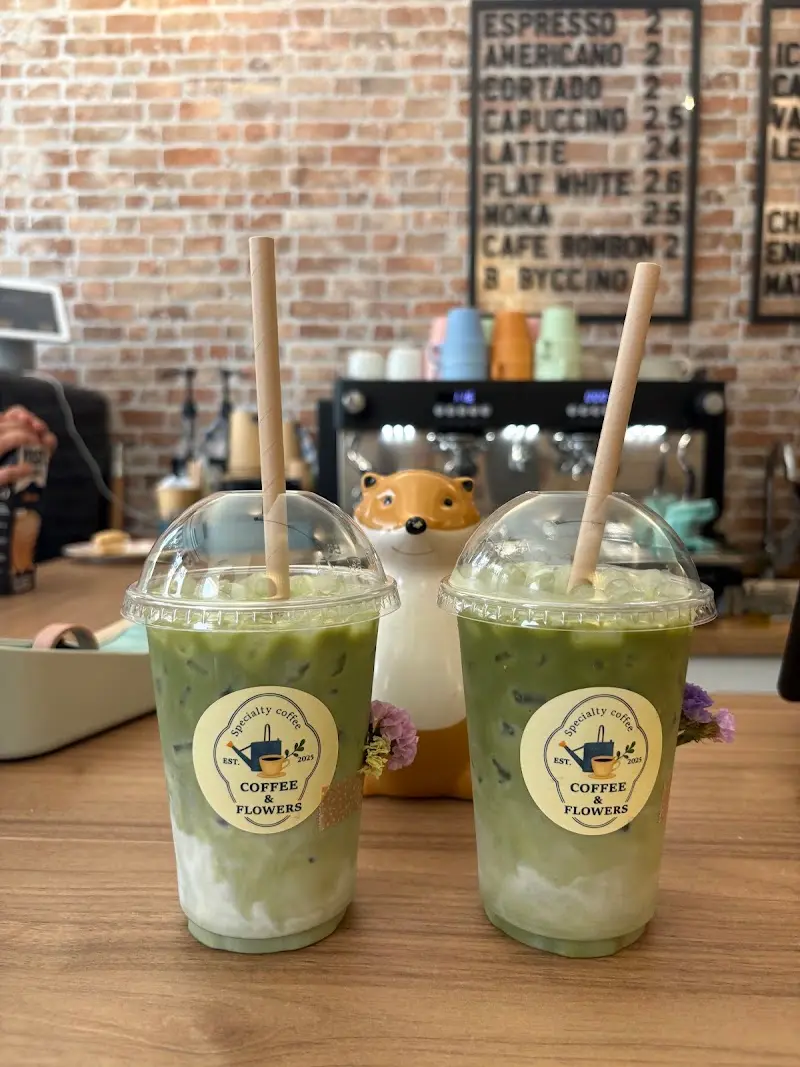 Dos matcha lattes con hielo en vasos de Coffee & Flowers sobre la barra