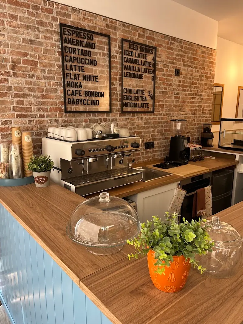 Barra con cafetera espresso, molinillo y carta de cafés en la pared de ladrillo