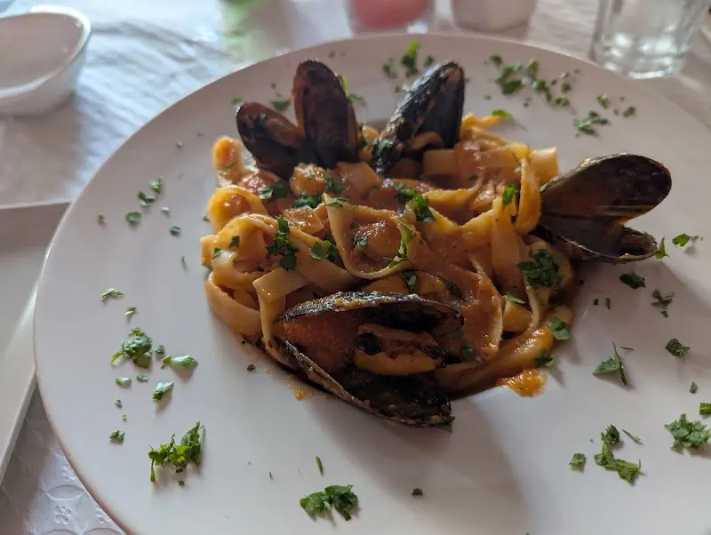 Tallarines con mejillones en salsa de tomate y perejil picado