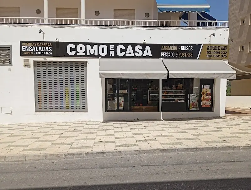 Fachada de Como en Casa con toldos y teléfonos de comida para llevar