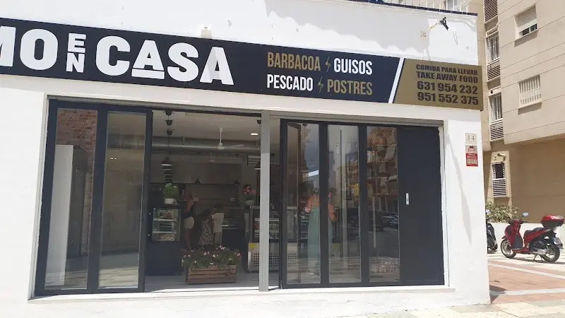 Escaparate acristalado con rótulo de barbacoa, guisos, pescado y postres