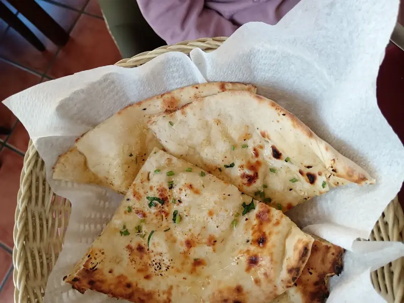 Cesta de pan naan al ajo con cilantro picado