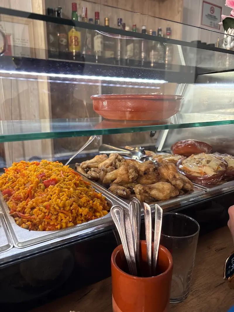 Vitrina de tapas con arroz amarillo, alitas de pollo y empanadas