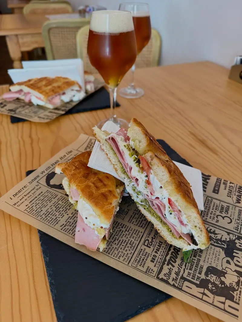 Focaccia rellena de mortadela, queso y pesto con dos copas de cerveza