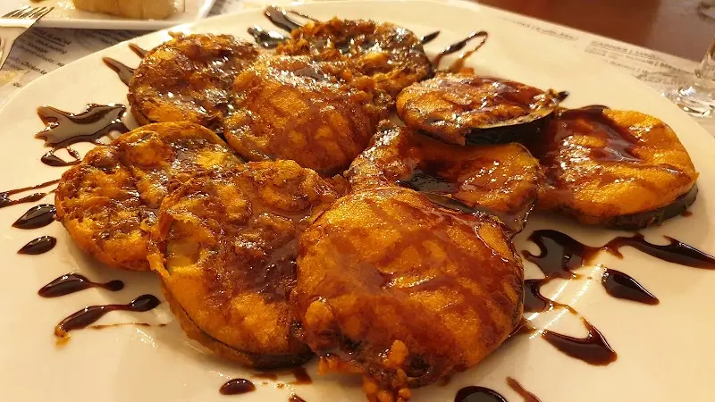 Berenjenas fritas con miel de caña en un plato blanco