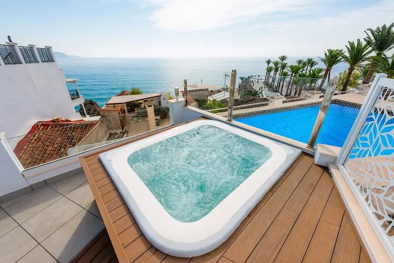 Jacuzzi sobre tarima en la terraza del HC Calahonda Beach, con piscina y el mar detrás