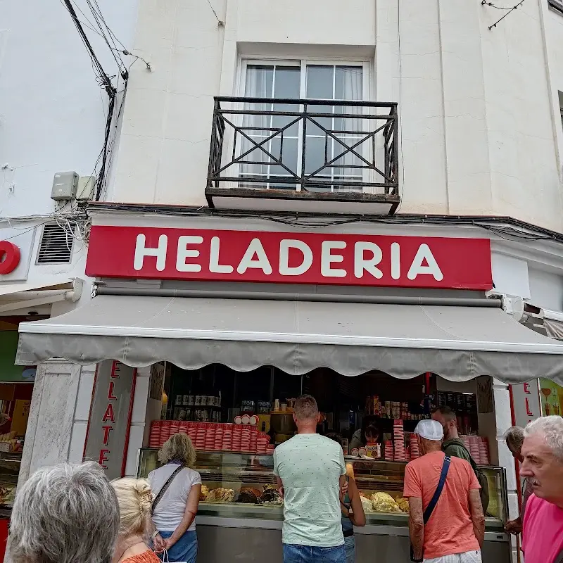 Clientes haciendo cola ante el mostrador bajo el rótulo rojo de heladería
