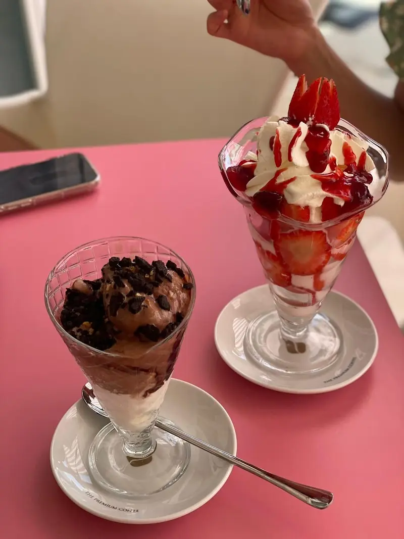 Copa de helado de chocolate con galleta y copa de fresas con nata y sirope