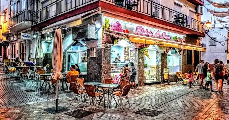 Terraza de La Ibense en una calle peatonal al atardecer, con paseantes y farolas