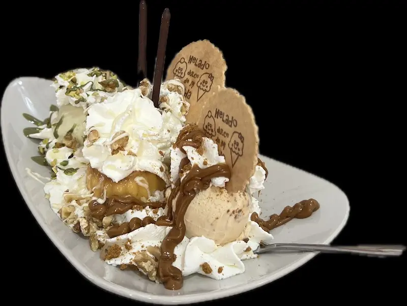Copa de helado con nata, caramelo, pistacho y barquillos con el logo de la casa