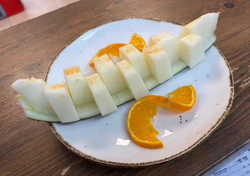 Plato de melón en trozos con rodajas de naranja de postre
