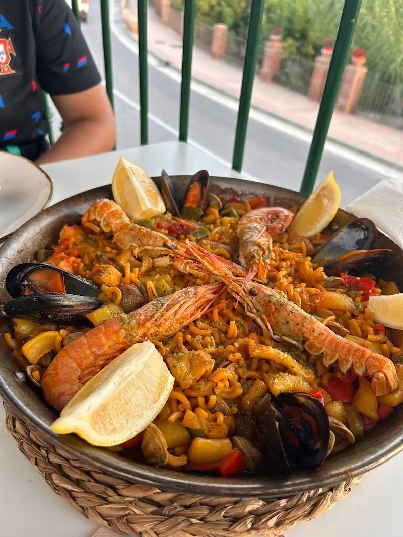 Fideuá con cigalas, gambas, mejillones y almejas en la terraza junto a la carretera
