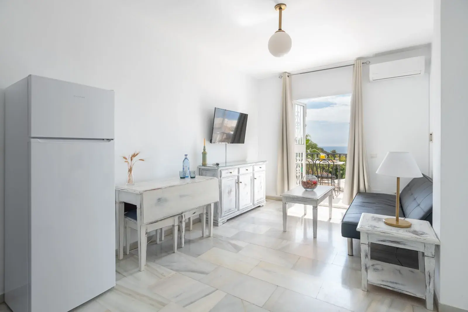 Apartamento con cocina, mesa de comedor, sofá y salida al balcón
