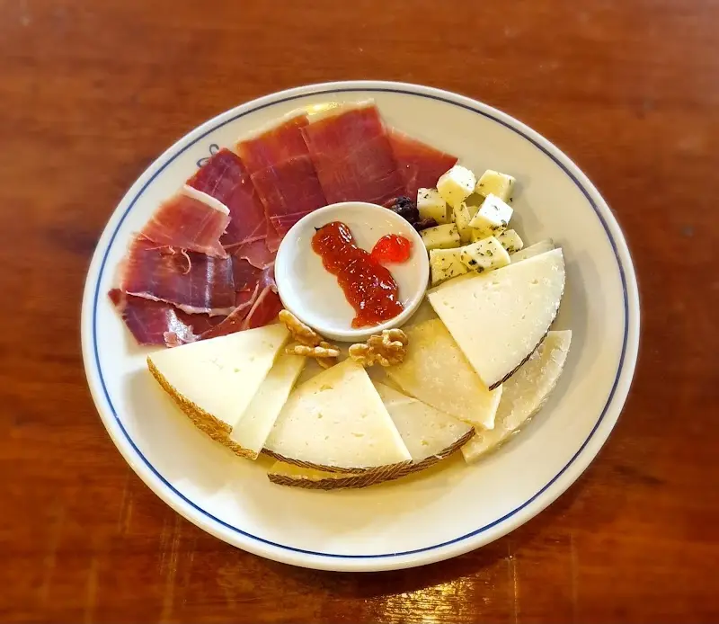 Tabla de jamón serrano y queso curado con taquitos de queso, nueces y mermelada