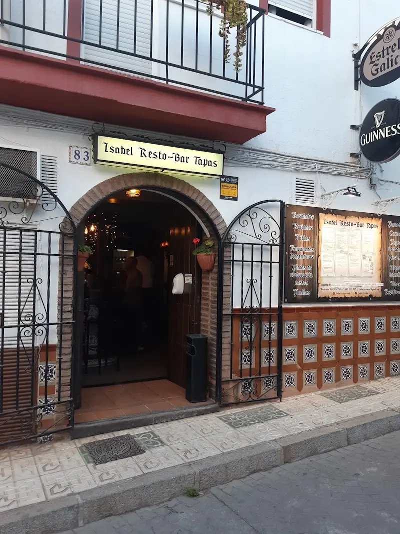 Entrada en arco con cancela de hierro y la carta expuesta en la pared exterior