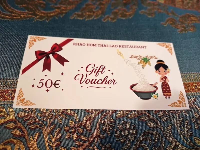 Tarjeta regalo de 50 € de Khao Hom Thai-Lao Restaurant sobre un mantel bordado