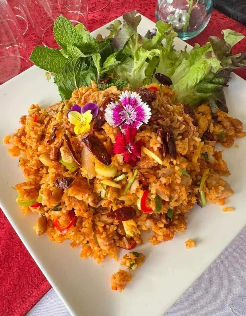 Arroz frito picante con guindillas secas, hierbabuena, lechuga y flores comestibles