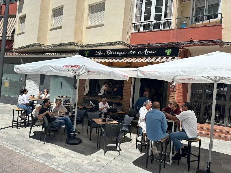 Terraza de La Bodega de Ana con sombrillas blancas y clientes sentados en un día soleado