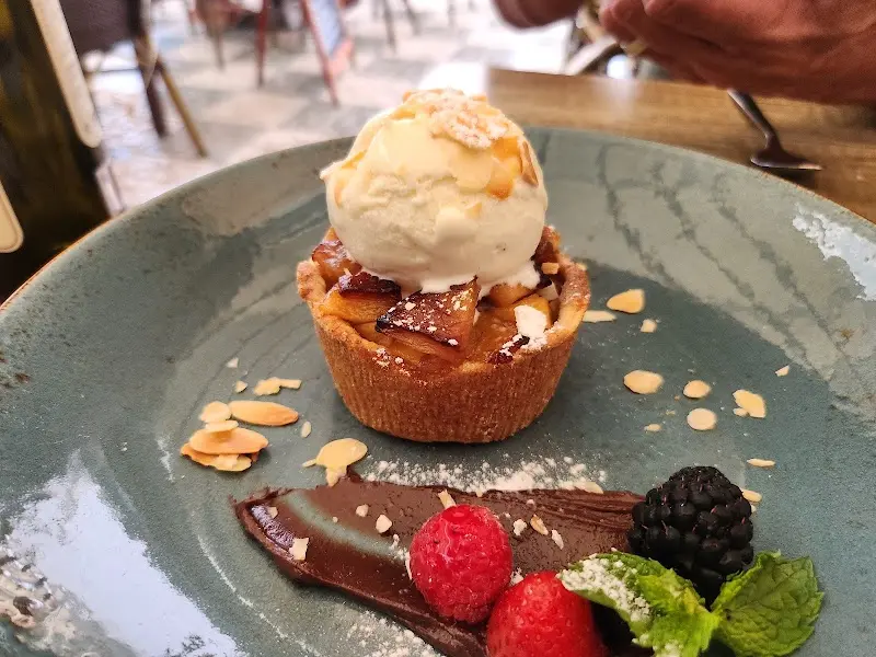 Tartaleta de manzana con bola de helado, almendras, chocolate y frutos rojos