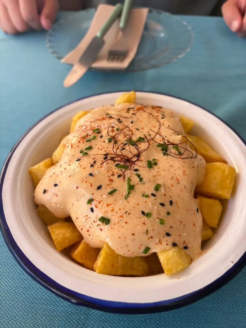 Patatas fritas en dados con salsa cremosa, pimentón, cebollino y sésamo negro